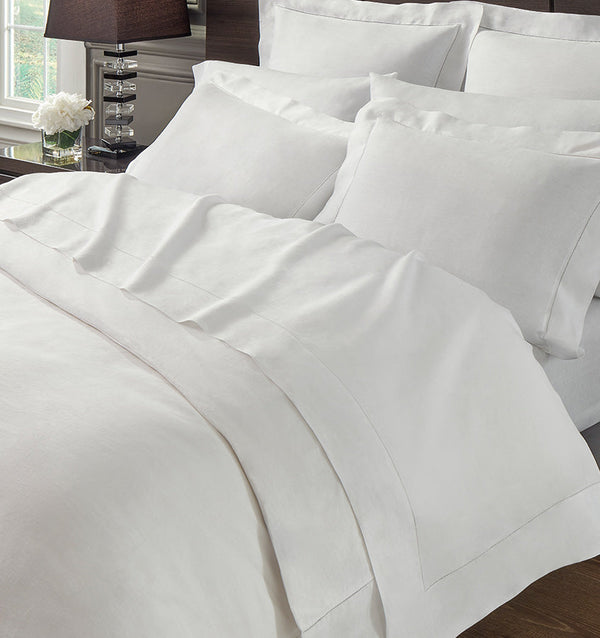 A bed with SFERRA Classico fine linen fitted sheets. 