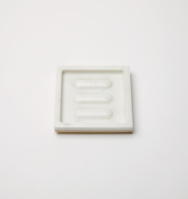 A rectangular marble SFERRA Pietra soap dish against a grey background.