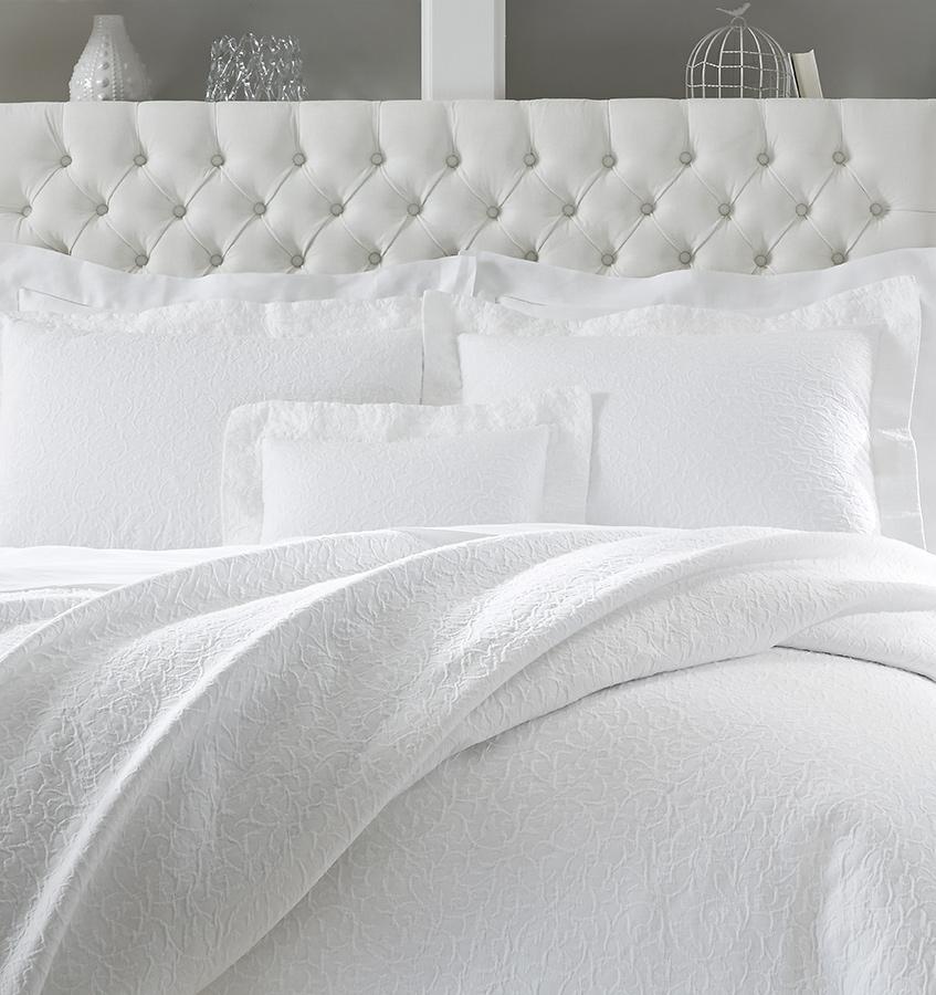 SFERRA Adelli prewashed textured cotton Coverlet on an all-white bed. 