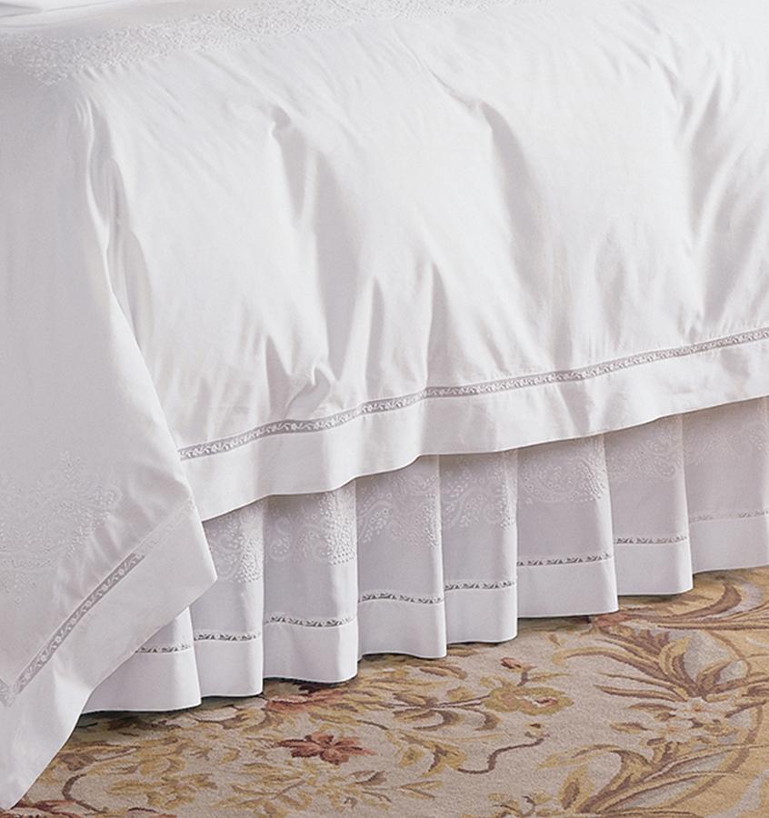 A luxury SFERRA Francesca bed skirt in a white hand-embroidered cotton with a lace inset.