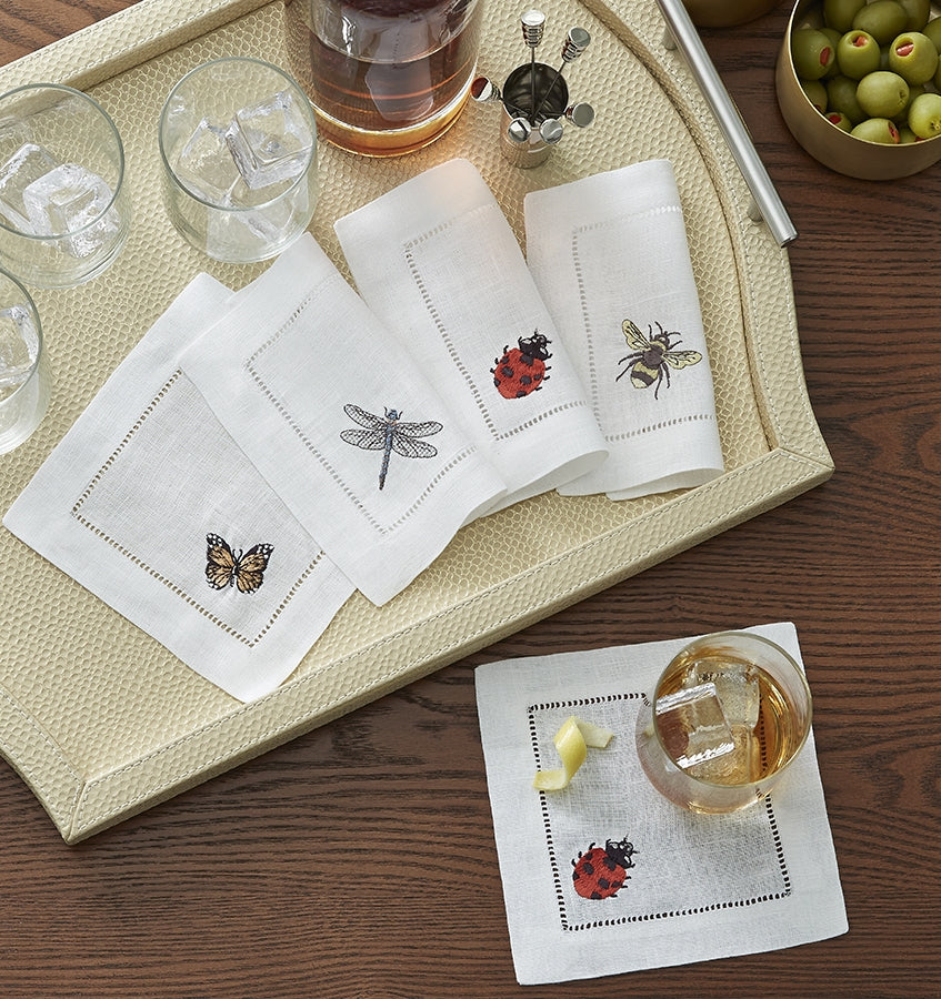 SFERRA Insetti cocktail napkins feature endearing insects on white hemstitched linen napkins.